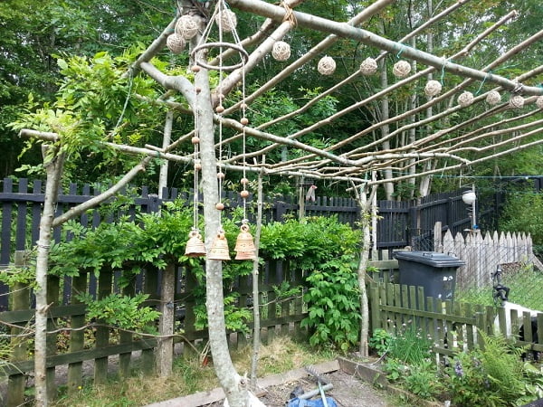 Pérgolas de madera rústica con ramas de árbol